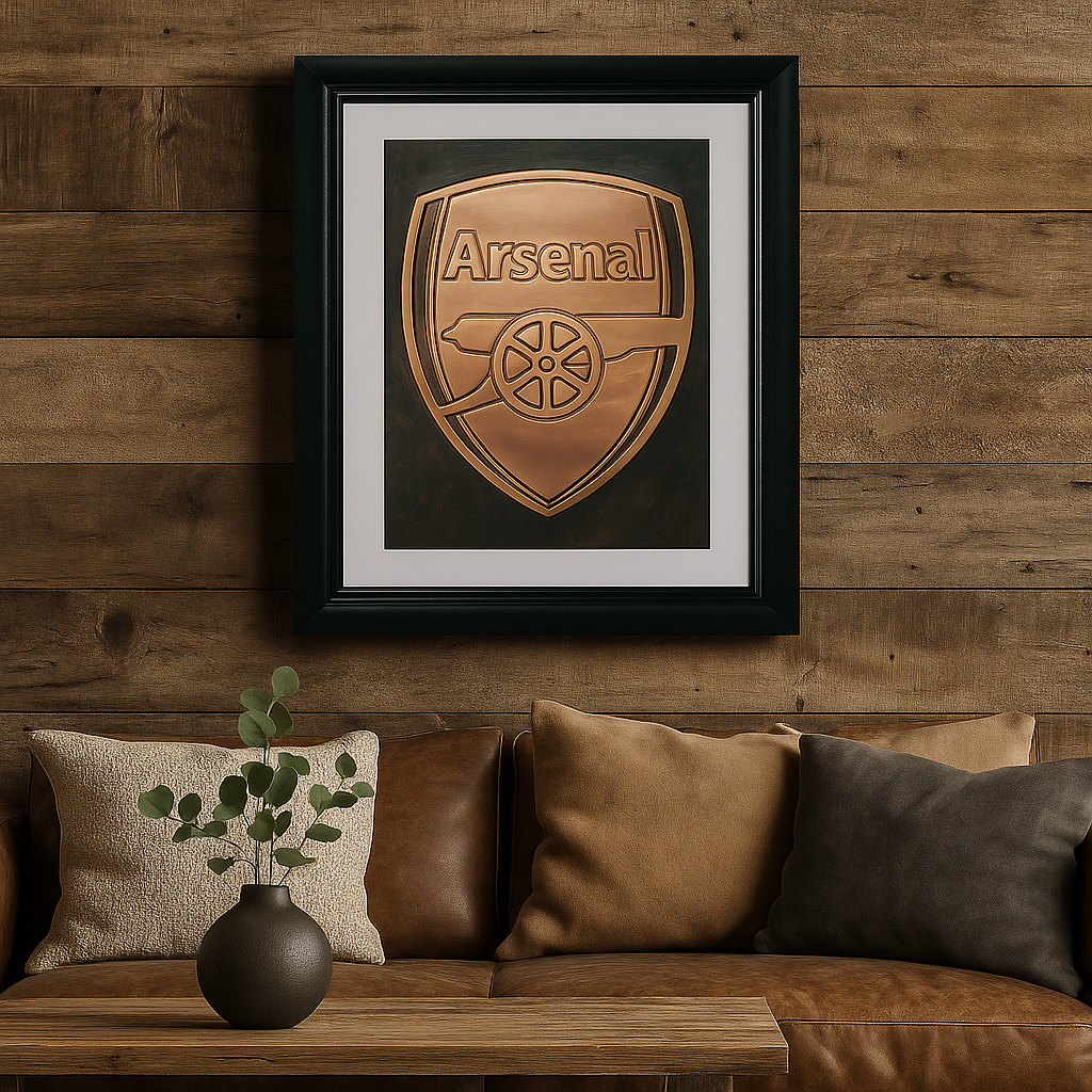 Framed Arsenal logo on a wooden wall above a brown sofa with decorative pillows.