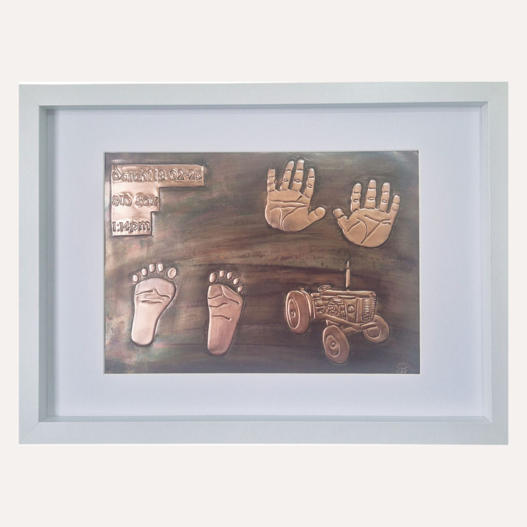Handcrafted copper baby keepsake with handprints, footprints, birth details and tractor design in white frame