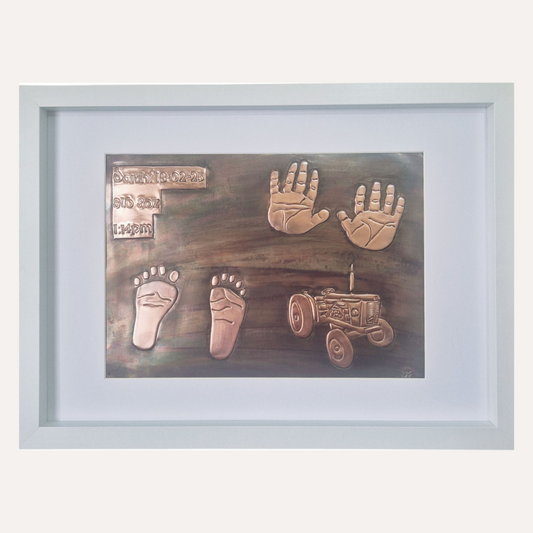 Handcrafted copper baby keepsake with handprints, footprints, birth details and tractor design in white frame