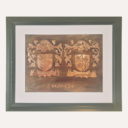 Handcrafted copper plaque featuring Doherty and Campbell family crests with ornate detailing and scroll banners