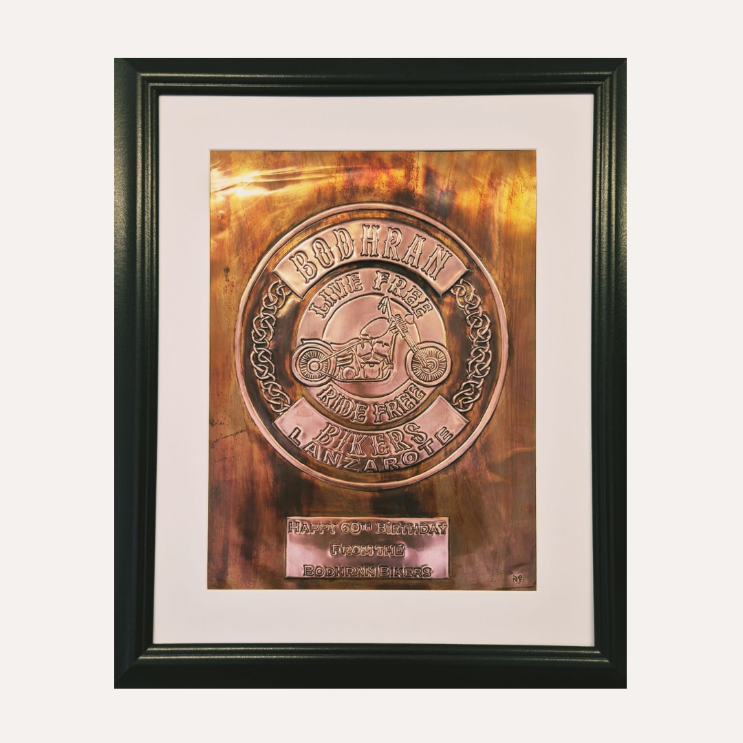 Framed copper plaque with decorative design and text on a white background