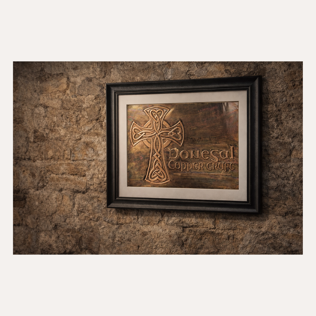 A lifestyle image of the Donegal Copper Craft logo is a handcrafted copper emblem inspired by Irish heritage, featuring a traditional Celtic cross with intricate knotwork and a rich, aged patina finish. Each logo is individually embossed by hand, giving it depth, character, and a timeless sense of craftsmanship.