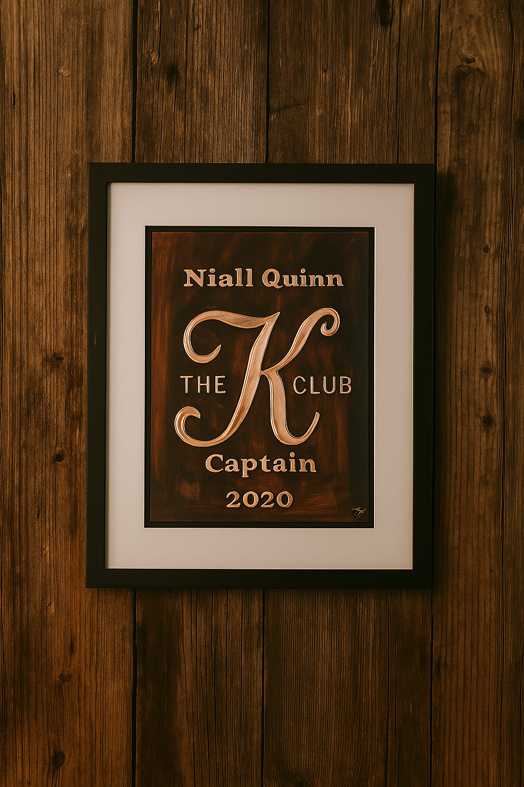 Handcrafted copper presentation plaque for Niall Quinn – The K Club Captain 2020, framed and displayed on a rustic wooden wall with warm, vintage decor – bespoke Irish-made artwork.