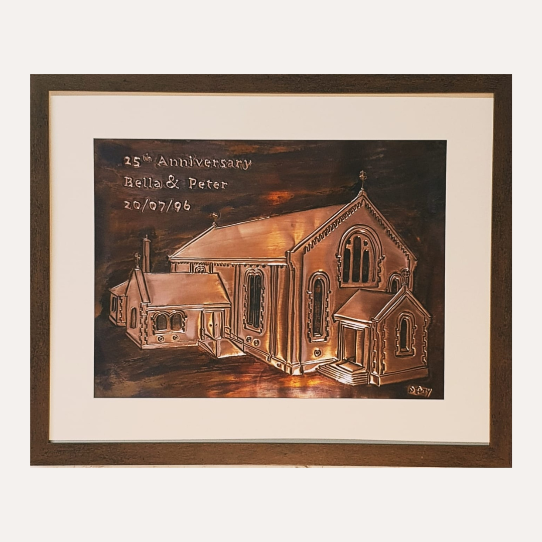 Personalised handcrafted copper anniversary plaque featuring a church portrait with engraved names, date, and 25th-anniversary inscription, framed in wood.

