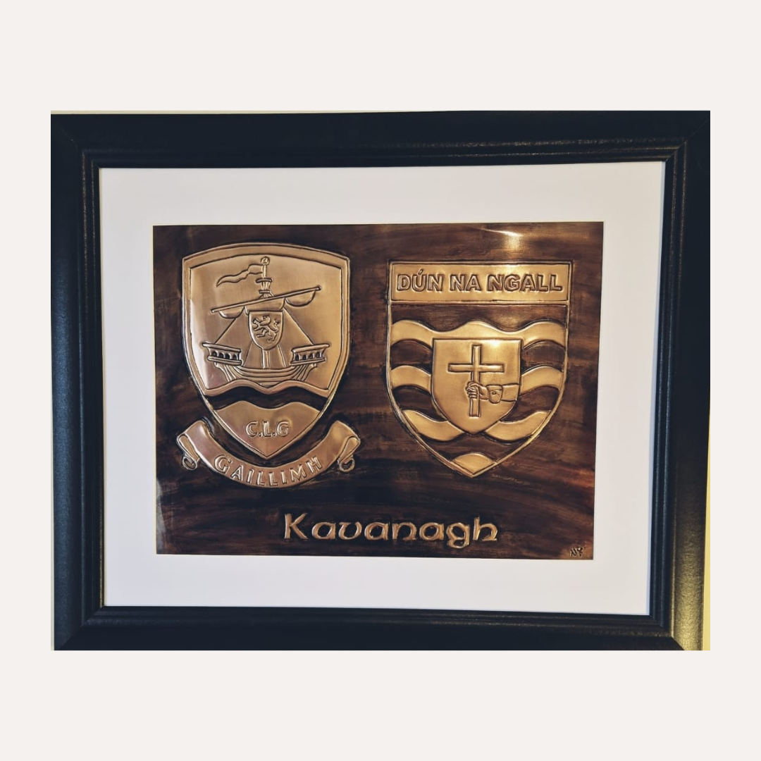 Personalised double copper sports crest wall art displayed in a modern living room, featuring Galway and Donegal GAA emblems and engraved surname.