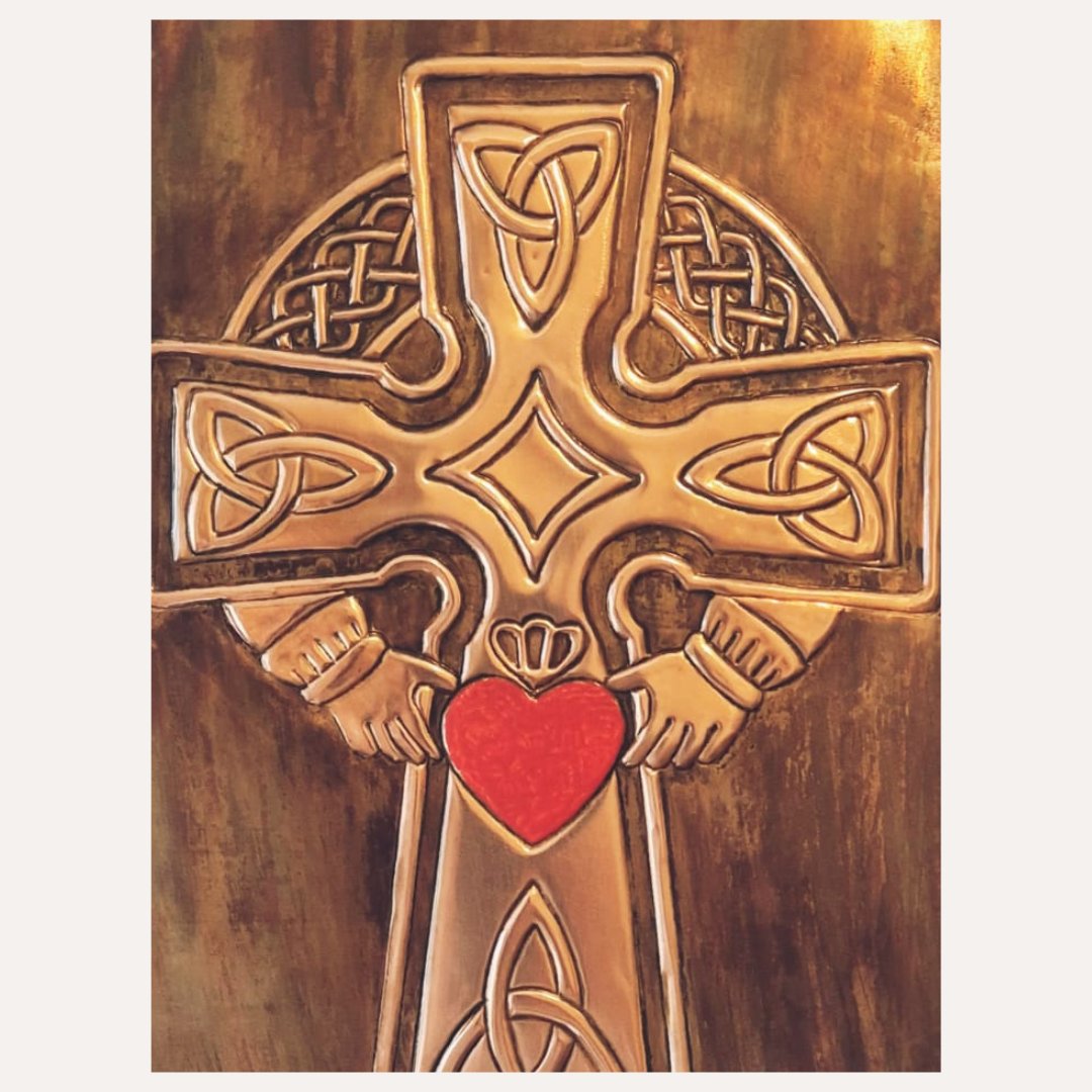 Close-up of handcrafted copper Celtic Cross featuring a red Sacred Heart held by Claddagh hands and detailed Celtic knotwork.