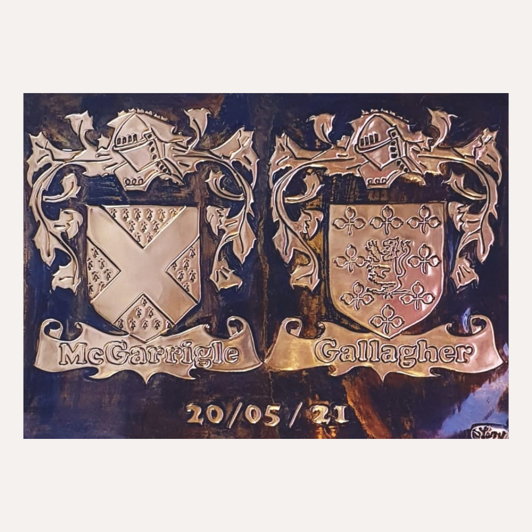Framed handcrafted copper double family crest plaque featuring the McGarrigle and Gallagher coats of arms with a personalised date engraving.